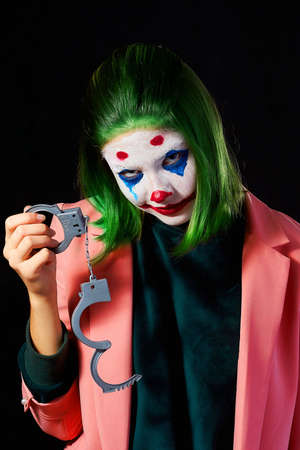 Makeup for halloween girl in Joker costume on dark background shooting in Studio.の写真素材