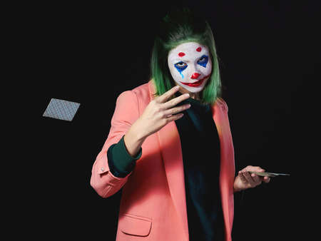 Makeup scary clown for a fun holiday model on a dark background in the studio.の写真素材
