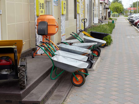 Carts for construction or agriculture stand on the sidewalk near the store.の写真素材
