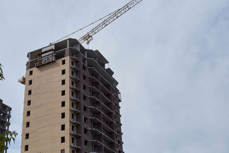Construction of a high residential building in the city center, without windows near a crane.の写真素材