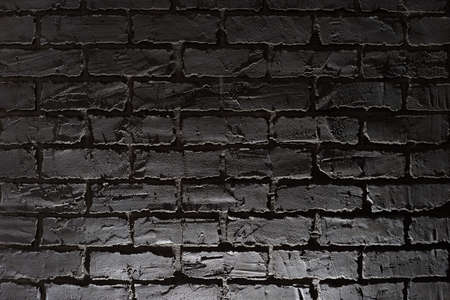 Decorative plaster on the wall in the form of gray brickwork with illumination in black style.