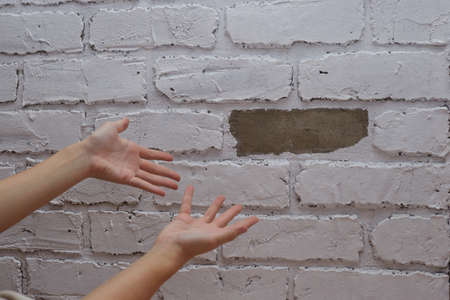 The inspector points his finger at the broken wall poor repair.の写真素材