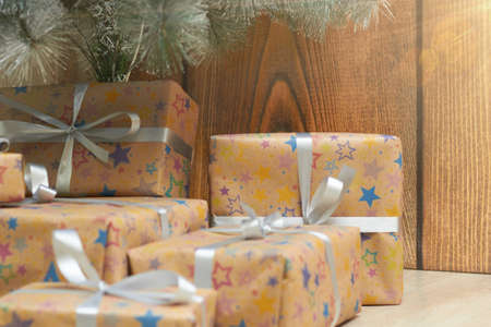 Christmas tree with colorful balloons and gift boxes on a wooden background.