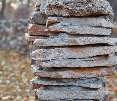 Stone fence in the park stone masonry in the autumn forest.の写真素材