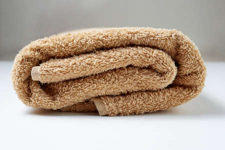 a rolled up brown towel is a hygiene and body care itemの写真素材