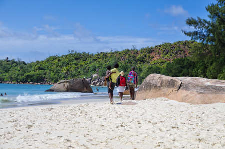 SEYCHELLES, PRASLIN - AUGUST 03: The family is walking along a Anse Lazio beach at Praslin island on August 03, 2015, Seychelles. Anse Lazio is considered to be the best beach on Praslin.のeditorial素材