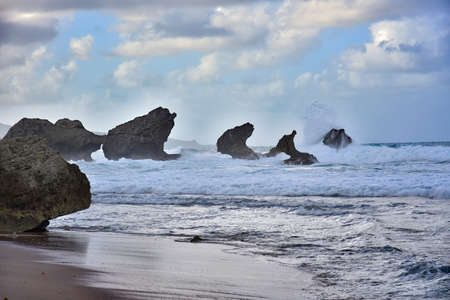 Rough ocean waves crashing against the rocky cliffs of North Point, Barbados, Caribbeanの写真素材