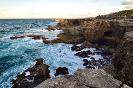Rough ocean waves crashing against the rocky cliffs of North Point, Barbados, Caribbeanの写真素材