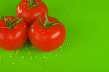 Three tomatoes on green, dropsの写真素材