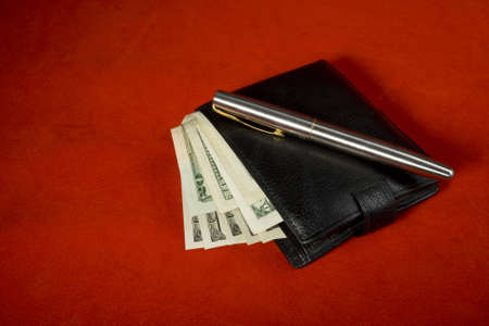 Wallet and pen on redの写真素材