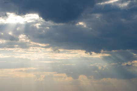 Storm clouds and rays of sun struggle through itの写真素材