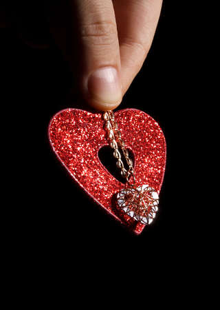 Fingers is holding red heart with necklace like a signs of loveの写真素材