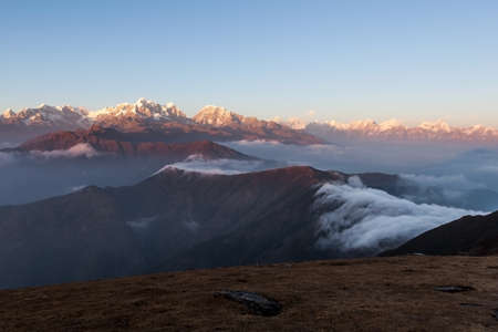 Amazing mountains landscape with beautifully floating clouds on the sunrise. Himalayas landscape with amazing mountains. Clouds flowing below high altitude snowy mountain peaks in Nepal.の写真素材