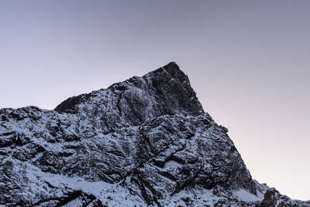 Rocky mountain peak near Cho La Pass in Sagarmatha National Park, Himalayas, Nepal. Snowy mountain summit in the early morning with clear purple sky. Beautiful mountain peak landscape in Himalayas.の写真素材