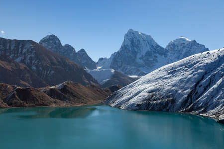 Amazingly beautiful scenery of Gokyo Lake turquoise waters under the clear blue sky on a sunny day. View from Gokyo Ri. Picturesque mountain moraine lake and snowy peaks landscape.の写真素材