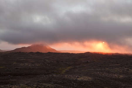 Beautiful sunset in empty lava field in Iceland. Deserted lava field covered with low clouds....