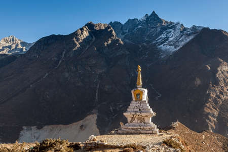 Buddhist stupa in Thame village with high rocky mountains on the background, Sagarmatha National Park, Himalayas. Chorten damaged during earthquake in Nepal in 2015.の写真素材