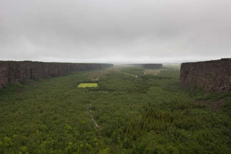 Famous horseshoe landscape near Asbyrgi, Northern Iceland. Huge cliffs surrounding green wet forest on a misty day. Green beautiful Icelandic scenery.の写真素材