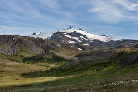 Iceland mountain landscape with white glacier cap of Snaefellsjokull volcano on horizon. Hiking in Saefellsnes peninsula in western Iceland.の写真素材