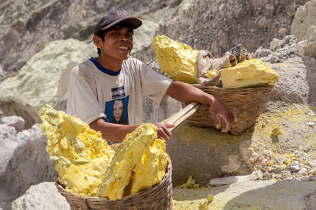 Java/Indonesia - May 8, 2015: Sulfur miner in Ijen volcano crater at Java island in Indonesia.のeditorial素材