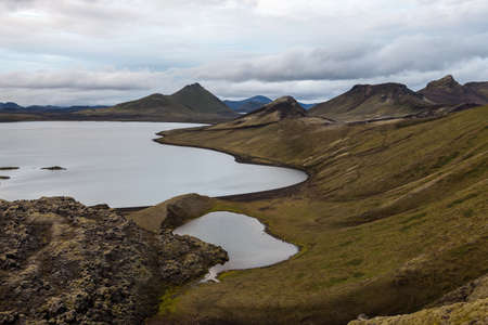 Landmannalaugar National Park. Calm lake and green hill slopes. Iceland adventure hiking Laugavegur trail to Landmannalaugar.の写真素材