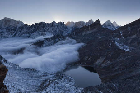 Beautiful moraine lake and snowy mountain peaks in the early morning lights in Himalayas, Nepal. Mirror water surface of a moraine lake at the foot of a glacier.の写真素材