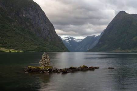Cairn in norwegian fjord on cloudy day. Beautiful norwegian landscape.