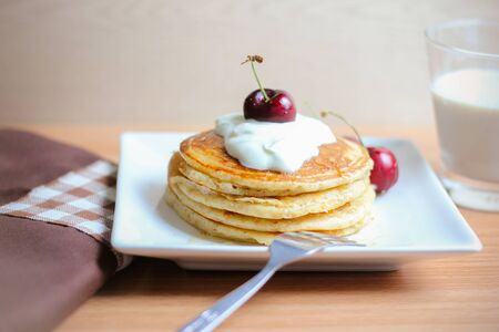 Breakfast whole wheat pancakes with cherry and yogurt.の写真素材
