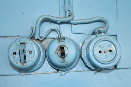 Old wall outlet and switch in a village house, Russiaの写真素材