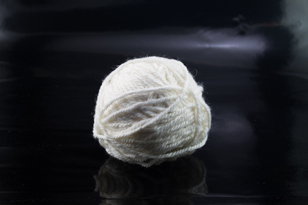 The white ball of wool thread on a black backgroundの写真素材