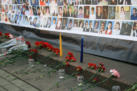Moscow, Russia - September 3, 2009. Funeral flowers near a poster with pictures of those killed in the Beslan children. Memorial meeting in Moscow on the anniversary of the terrorist attack. Memorial meeting on the anniversary of the terrorist attack in Bのeditorial素材