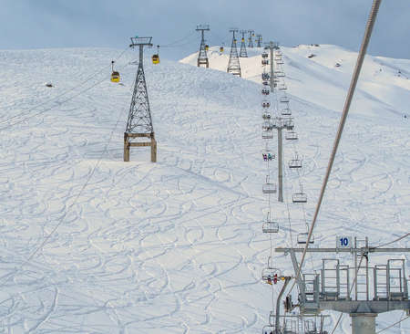 Gondola cabins, Ski Lift and mountain ski slopes during the winter season.の写真素材