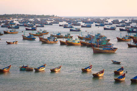 Big number of fishing boats near the coast of one of the fishing village in Vietnam on sunset..の写真素材