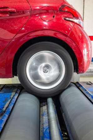 Brake test performance rear wheel drive in a car laboratory with the tire rolling on the rollers of the brake testerの写真素材