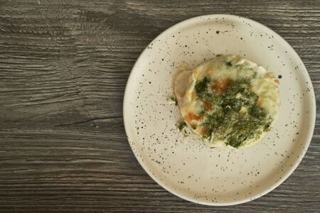 fish lasagna in a plate on a wooden table