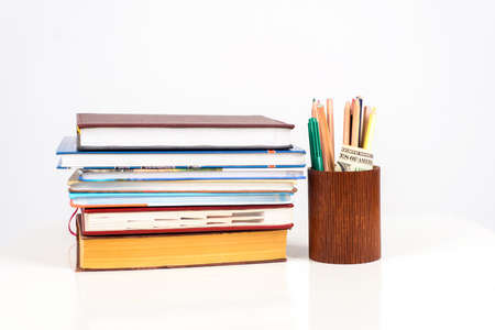 a neat stack of colorful Books with School supplies on tableの写真素材