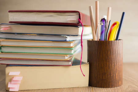 attainment of knowledge: a pile of books with bookmarks, glasses and pencils in a pencil standの写真素材