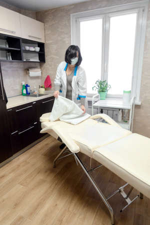 female cosmetologist working in the office with a white couchの写真素材
