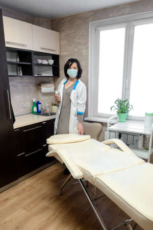 female cosmetologist working in the office with a white couchの写真素材
