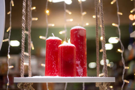red candles on the stand, behind the garlandの写真素材
