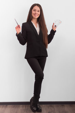 girl with make-up with long dark hair in a business suit holding a brush and a palette for mixing creams, on a white backgroundの写真素材