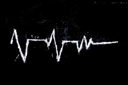 white powder (heroin, cocaine, narcotic) scattered in the form of a cardiogram on a black backgroundの写真素材