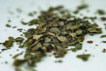 green dry crushed leaves (marijuana, tobacco) on a white surfaceの写真素材