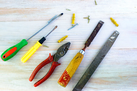 Repair tools on a wooden light background: file, pliers, pliers, screwdriver, screws, boltsの写真素材