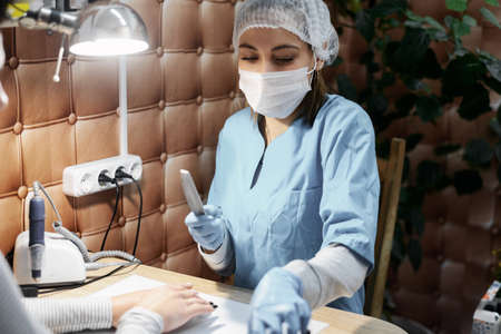 Manicurist and nail extension in the office, salon