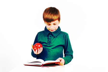 graphic image: boy schoolboy is preparing for school, reading something in a notebook, holding a red...