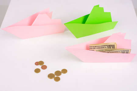 Business concept, 3-paper boats sailing forward and money on Board, a few coins aheadの写真素材