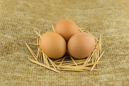 a healthy diet rich in protein: 3 large red eggs lie in an artificial nest made of toothpicks on...