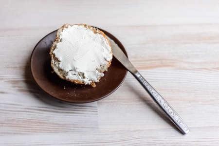 diet Breakfast: fresh baked muffin slathered cream cheese frosting on white wooden table