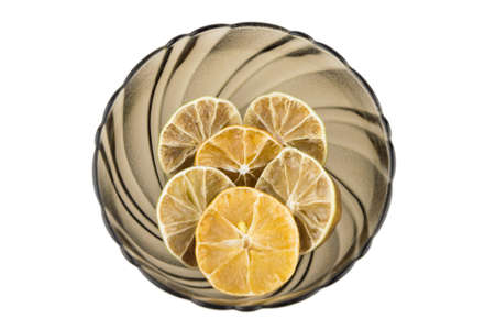 dried slices of Mandarin and lime, in a Cup of dark shaped glass, designed for aromatization and home decoration isolated on whiteの写真素材
